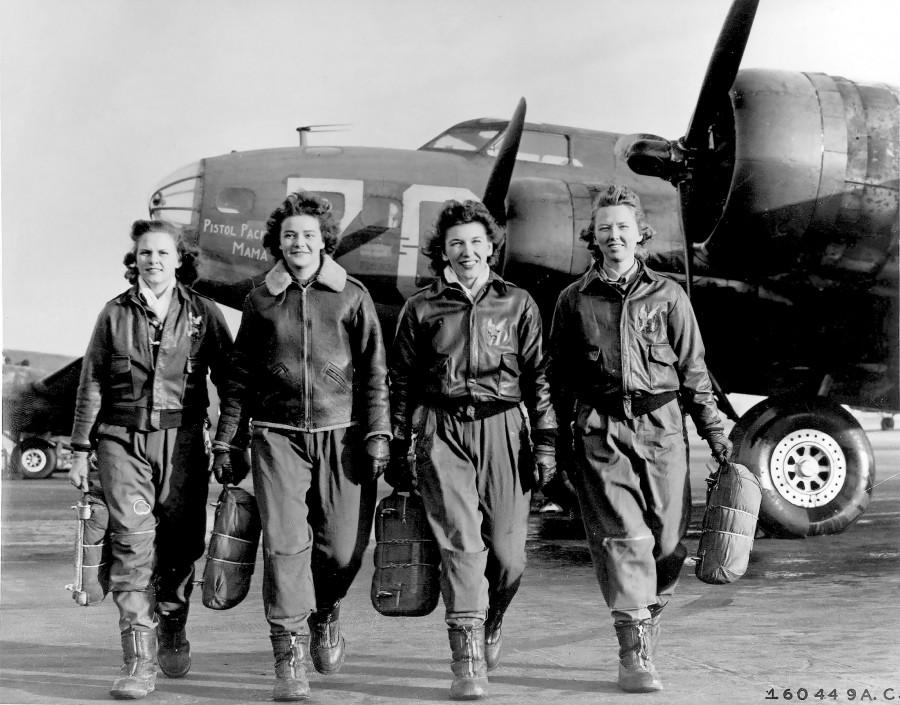 Four WASPs return after a successful flight on their B-17, nicknamed Pistol Packin Mama, carrying their parachutes. As veterans from WWII, the WASPs have been fighting for the same benefits as any other veteran, including the right to be buried in Arlington. 