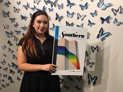 Holding up a poster cover of the newly released Southern Cultures, UNC freshman Mitra Norowzi attends the Fall Issue release party at the 21c Hotel in Durham. Mitra is thankful for her position to work on the editorial team for the journal.