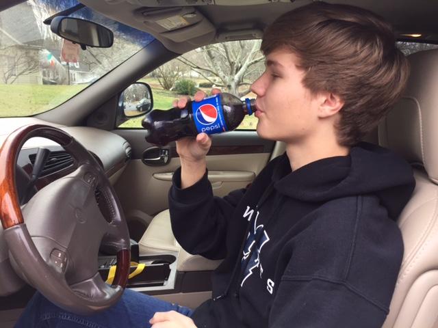 Eating lunch in his car, junior Adam Wenzel enjoys the famous soft drink invented in North Carolina, Pepsi. Pepsi is one of many famous inventions right here in North Carolina.