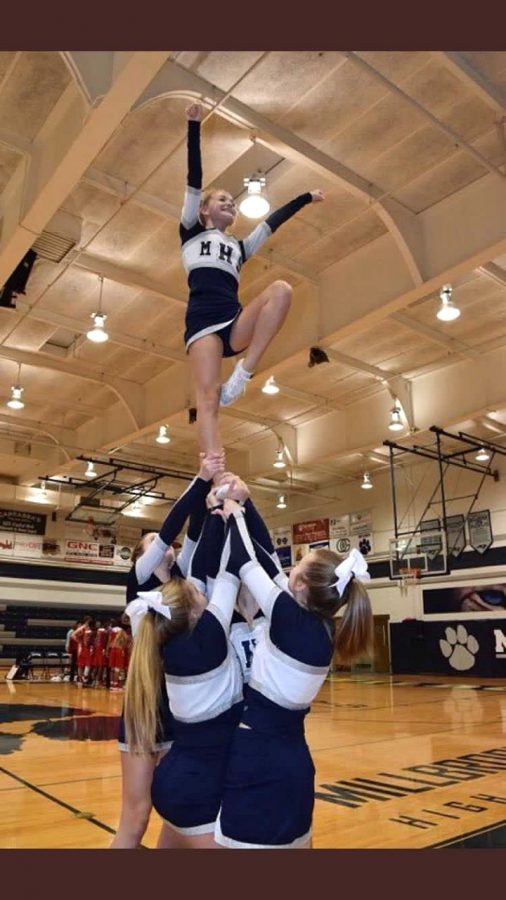 Hitting a lib in an extension, cheerleader Jesse Crossland uses strength and balance while being in the air on one foot. This is one of many stunts that cheerleaders do. 