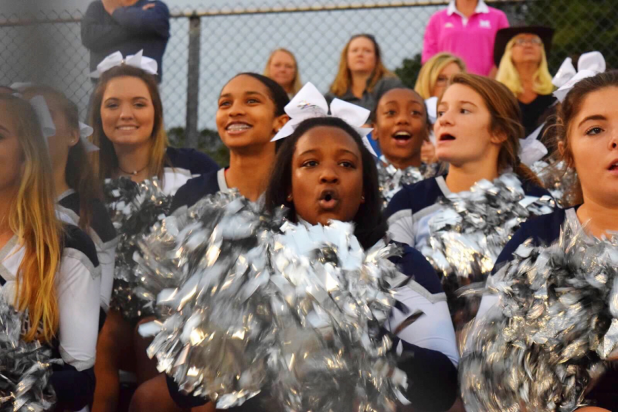 Leading the crowd at a football game, Bria Bryant cheers on her team with the other varsity cheerleaders. This is just one of many ways Bria shows her school spirit at Millbrook.