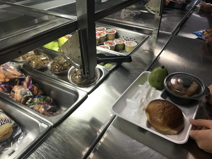 Moving down the line, a student picks out food items from an array of options in our cafeteria. Many students feel dissatisfied with the quality of the school lunch and gave input on how it could be better.