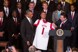 Celebrating their 2013 National Championship with then President Barack Obama, former Head Coach Rick Pitino hands him a commemorative jersey. The team has now been stripped of this title and all wins spanning from 2011-2015. 