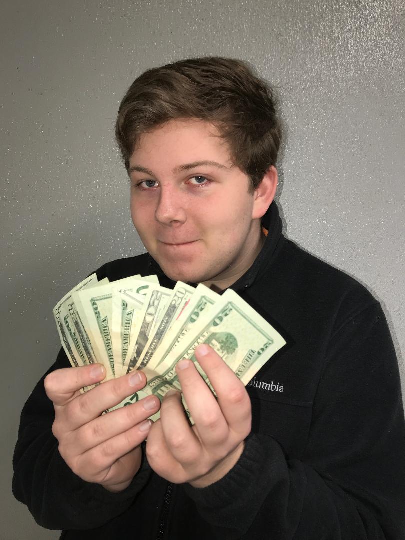 Showing off his cash, sophomore Gray Doby has more than enough money to buy a Cookout tray, but not enough to go out to dinner with his friends at The Angus Barn. This young man demonstrates the balance between not having enough money, and having too much, which is the equation for being the happiest one could be.