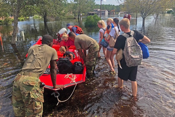 Fleeing their home, a family of Wilmington residents leave their house to escape the flooding with help from the North Carolina National Guard. Over a week after the deadly Hurricane Florence, people still remain in shelters because of the damage.