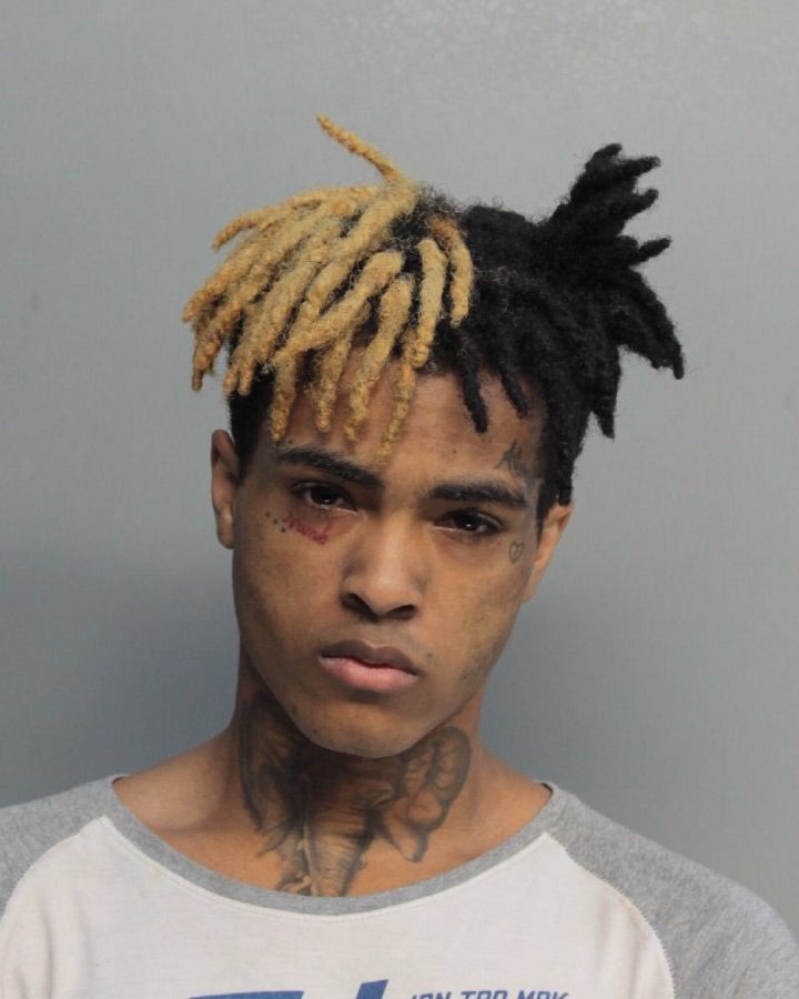   Used as the cover for his single, “Look at Me!”, Jahseh Onfroy poses for his mugshot. Onfroy was shot and killed in June of 2018, but some people believe that he is not actually dead. 
