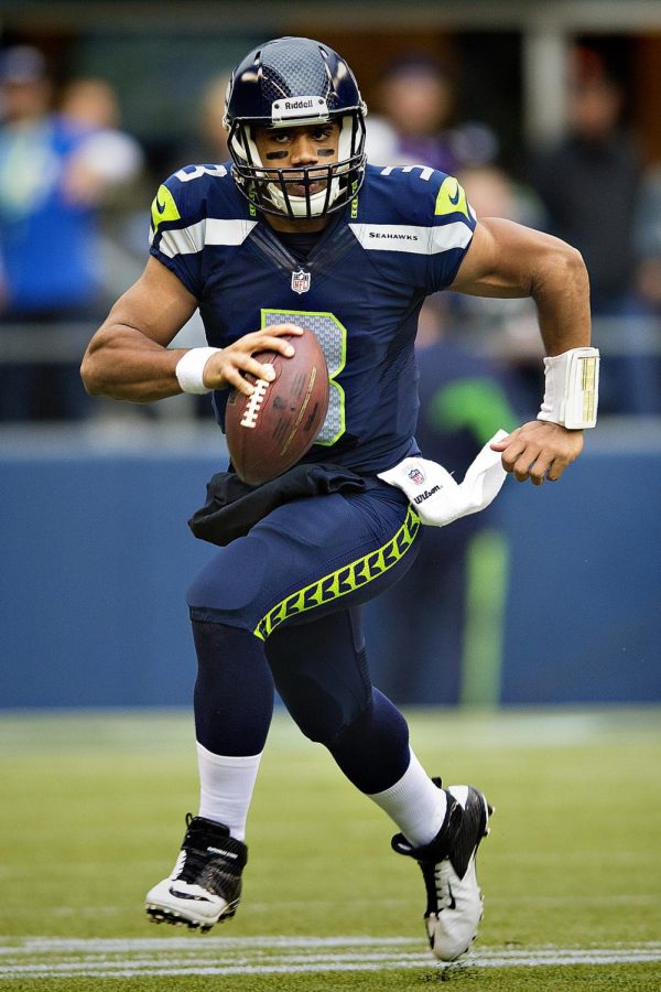 Running+down+the+field+with+the+ball%2C+Russell+Wilson+looks+for+a+teammate+in+the+endzone+to+pass+the+ball+to.+Wilson+is+one+of+the+many+athletes+in+the+past+to+chose+football+over+other+sports%2C+but+with+increasing+knowledge+on+concussions%2C+could+we+begin+to+see+a+new+trend+in+sports%3F+