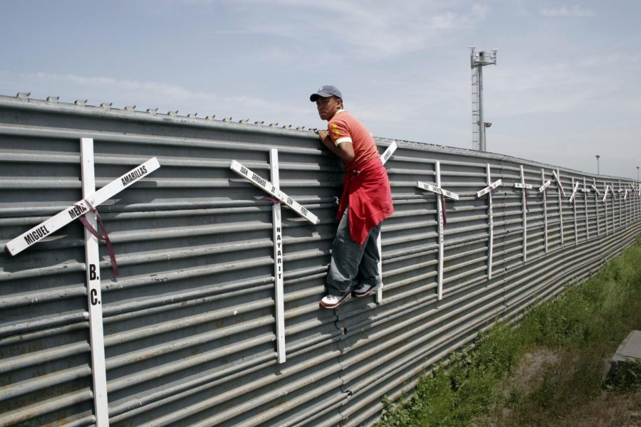 Climbing the fence, a young man looks over the border-fence. Samuel Oliver-Bruno, an illegal immigrant in Durham, NC, has been recently arrested by ICE when he left the church he was staying at to meet the requirements for his petition to delay his deportation.