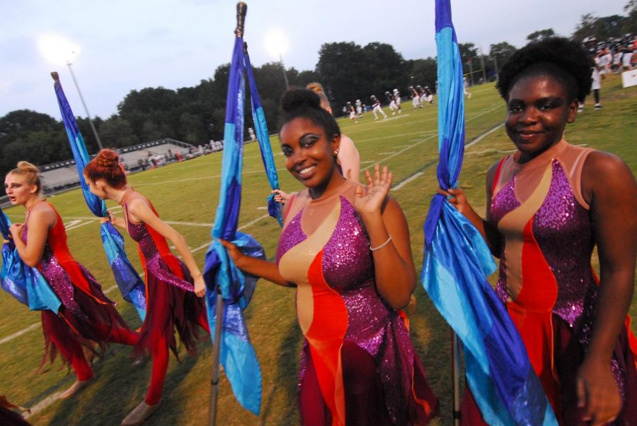 Exiting+the+field+after+the+homecoming+pregame%2C+senior+Iyah+Dixon+and+junior+Michelle+Bina+head+to+the+bleachers+to+wait+for+halftime.+Their+next+performance+is+October+11+at+the+Millbrook+football+game.