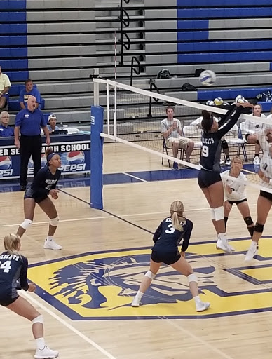 Jumping up to stop the ball from entering her side, Reychel Douglas attempts to prevent  the other team from scoring. Reychel is a freshman, and being on Millbrook’s Varsity Volleyball team shows just how spectacular she is!

