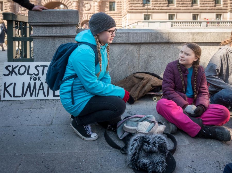 Engaging with a fellow student participant, Greta Thunberg (right) protests climate change outside the Swedish parliament. Now, 149 countries and 3.6 million people are involved in her school strikes.