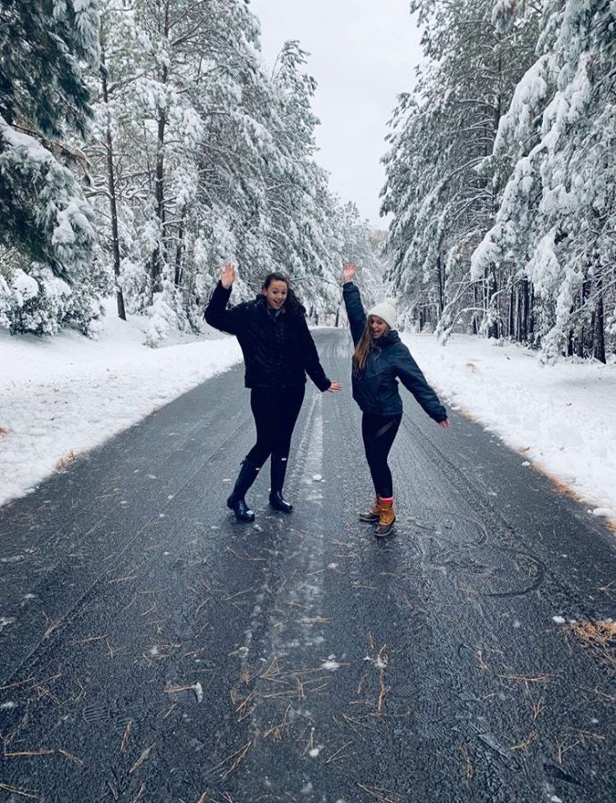 Hanging out with friends, junior Julia Hull stops for a photoshoot in the snow. Spending time outside in the snow is a great way to have some physical activity.