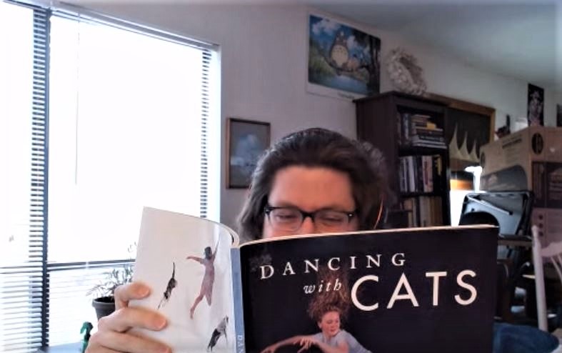 Pretending to read Dancing with Cats, Mr. Oliver shares with us a glimpse of his light-hearted sense of humor. Mr. Oliver has read an impressive number of books, yet he chose this one, displaying his humble character.
