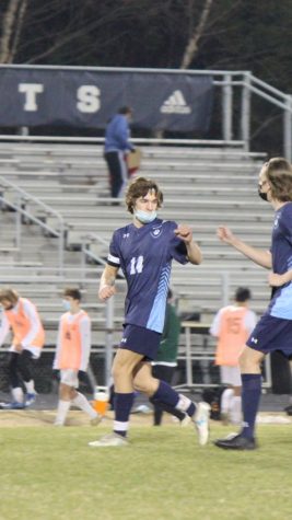Running back after a goal was scored, in their first game, Will Jurney fist-bumped fellow senior Callum Monteith. This goal scored here would not be enough to win against Enloe,  but is the only loss the boys have had thus far. 
