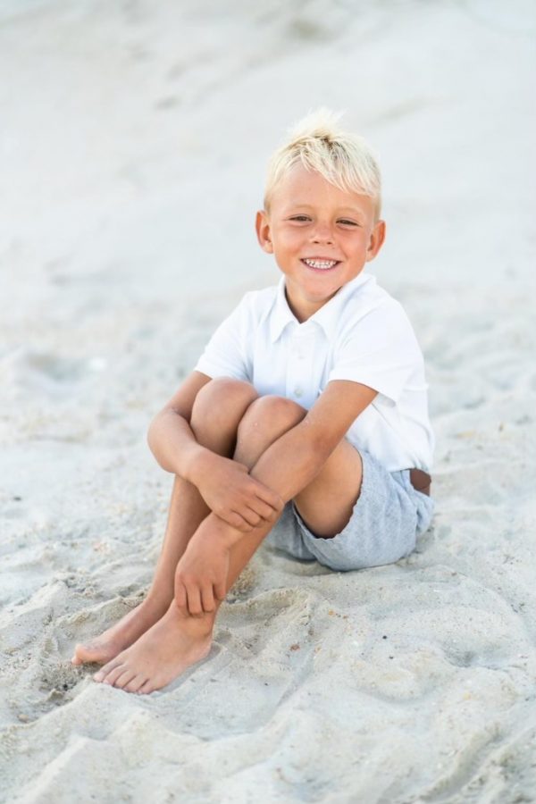 Sitting on the sand of Topsail Beach, six-year-old Aven Moffat smiles widely at his family. Topsail was a place that the Moffat family has always used to get away, and it became one of Aven’s favorite places.