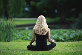 A woman is easing her stress levels by accomplishing a common meditation exercise. These types of meditation exercises can allow for relaxation to help make taking a test less stressful than it already is.