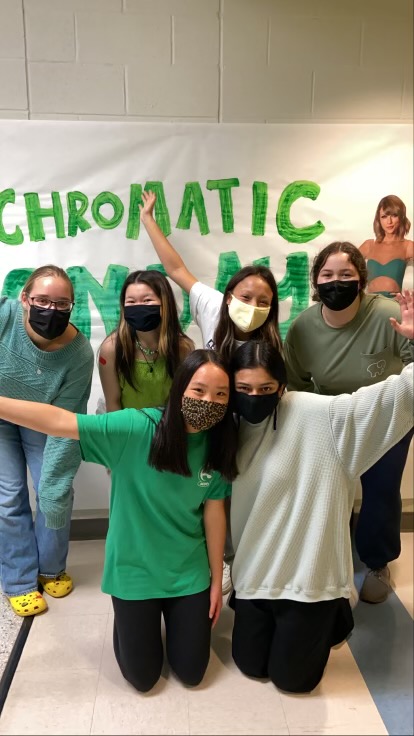 Smiling, Millbrooks Psychology Club poses together in green. Psychology Club is asking all students to wear green this Friday, October 8th to spread awareness for Mental Illness Awareness Week.