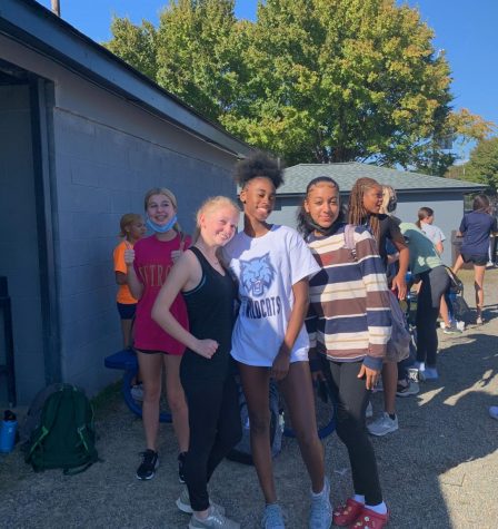 Indoor track and field runners, Hannah Frederick, Ella Patchin, Amauri Anderson, and Alyiah smile as they pose for a picture waiting for tryouts to start