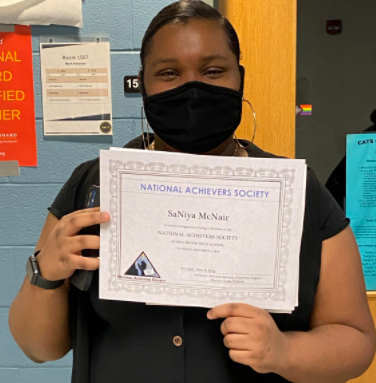  Sophomore Saniya McNair is holding her National Achievers Society member certificate. She is beaming with excitement over her certificate.
