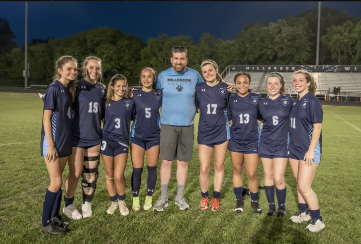 Head Coach Mr. Scanlon stands happily with the seniors on their senior night.
The season has gone very well for these ladies, and they hope to end it on a high note. 
