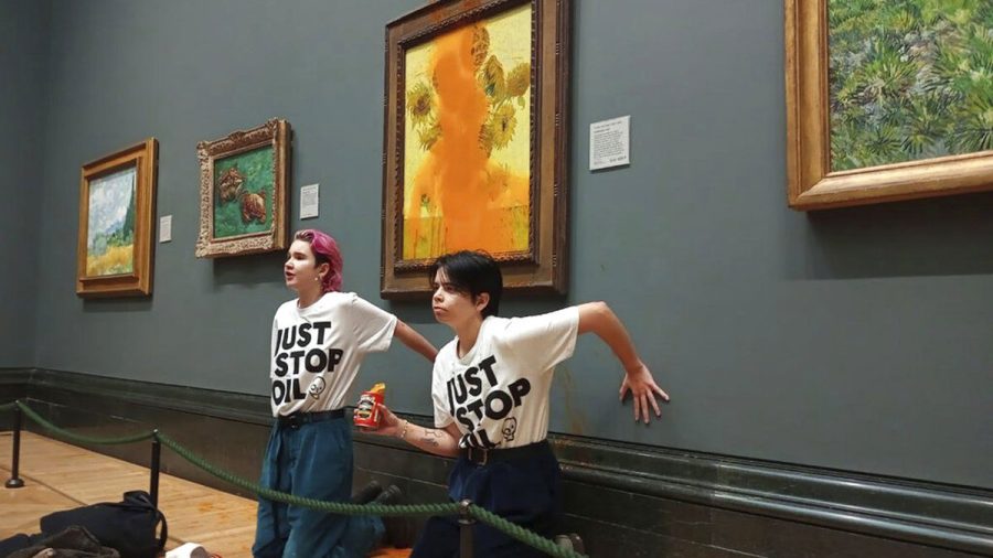 Protesters sit super-glued to the wall underneath the vandalized painting, “Sunflowers” which was protected by glass and saw only minor damages to the frame. Specialized officers came soon after to remove and arrest the individuals.