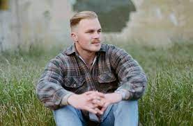 Bryan in a field posing for his next album cover, expected to be released early 2023