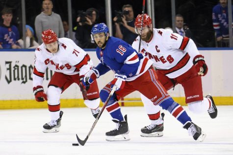 Two Hurricanes Jesper Fast (71) and Captain Jordan Staal (11) raced ex-teammate and now Rangers forward, Vincent Trocheck (16)  to the puck during the rivalry game last night.  

