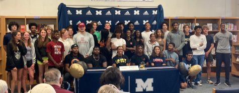 Team members of the signed athletes show their support for their teammates as they pose for a picture after signing day. 
