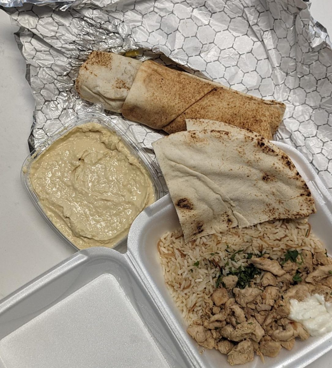 At the Raleigh “Taste of Lebanon” cultural festival various Lebanese foods were offered for visitors to try. Pictured above (clockwise) is a chicken shawarma sandwich, chicken shawarma rice platter, and hummus.
