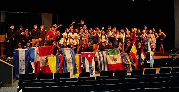 Members of the Hispanic Heritage Show take a group photo with teacher coordinator, Mrs. Amaguayo, along with the different flags of Hispanic countries. 