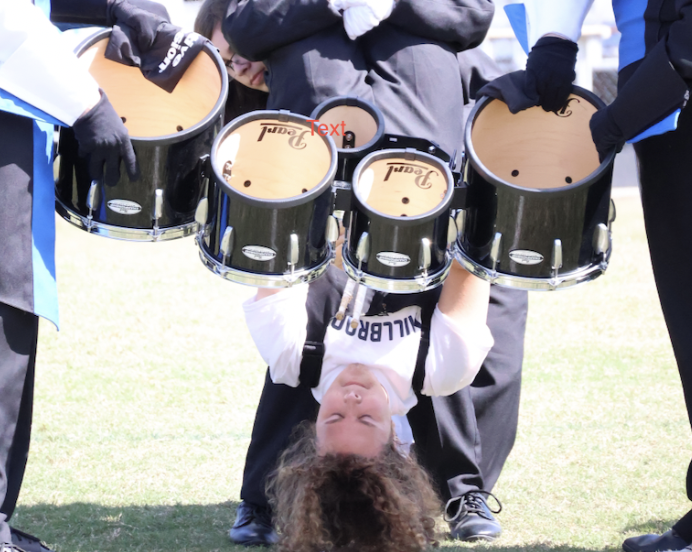 Senior Will Davis playing the drums upside down at the HOCO pep rally. Millbrook High School band has made many efforts to express themselves to their community. 

